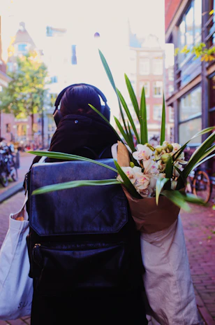 A musician effortlessly carrying a compact Beatsphere speaker through a vibrant city park.