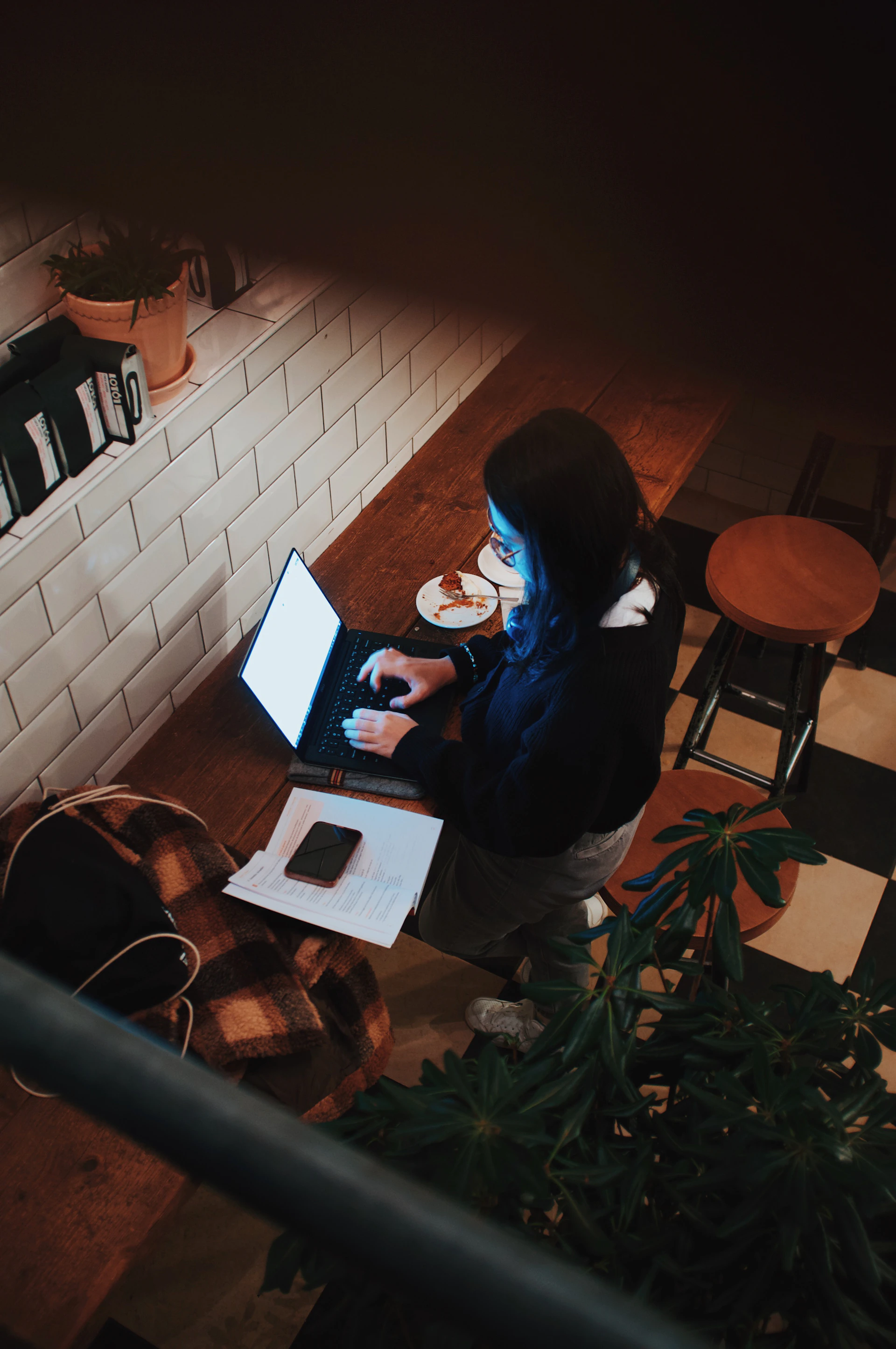 a woman sitting at a table using a laptop computer