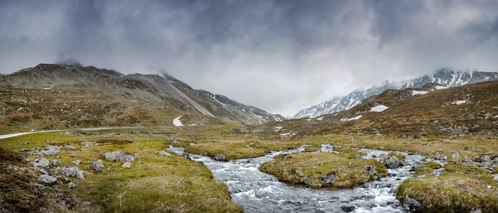 a stream running through a lush green valley