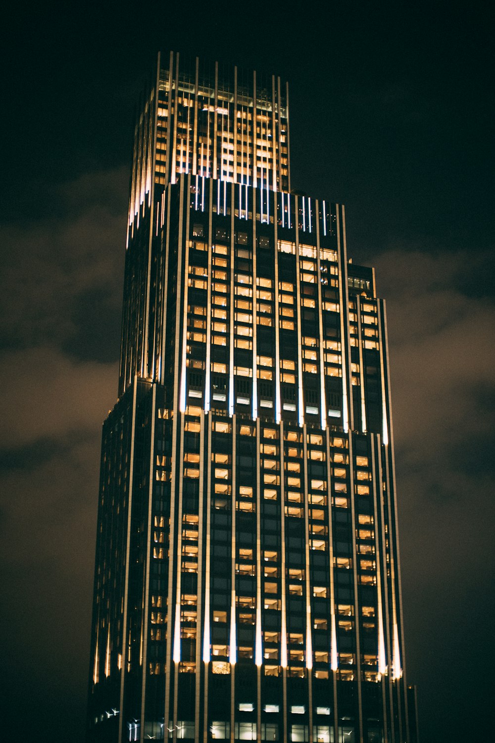 Un edificio muy alto iluminado por la noche