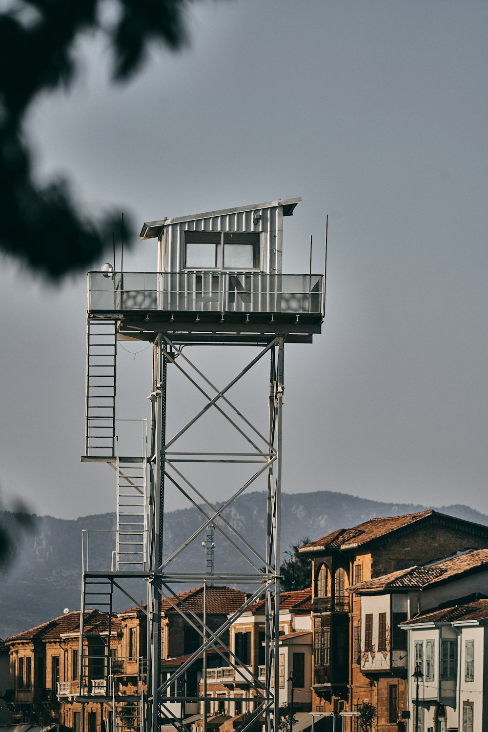 a tall metal tower sitting next to a row of buildings