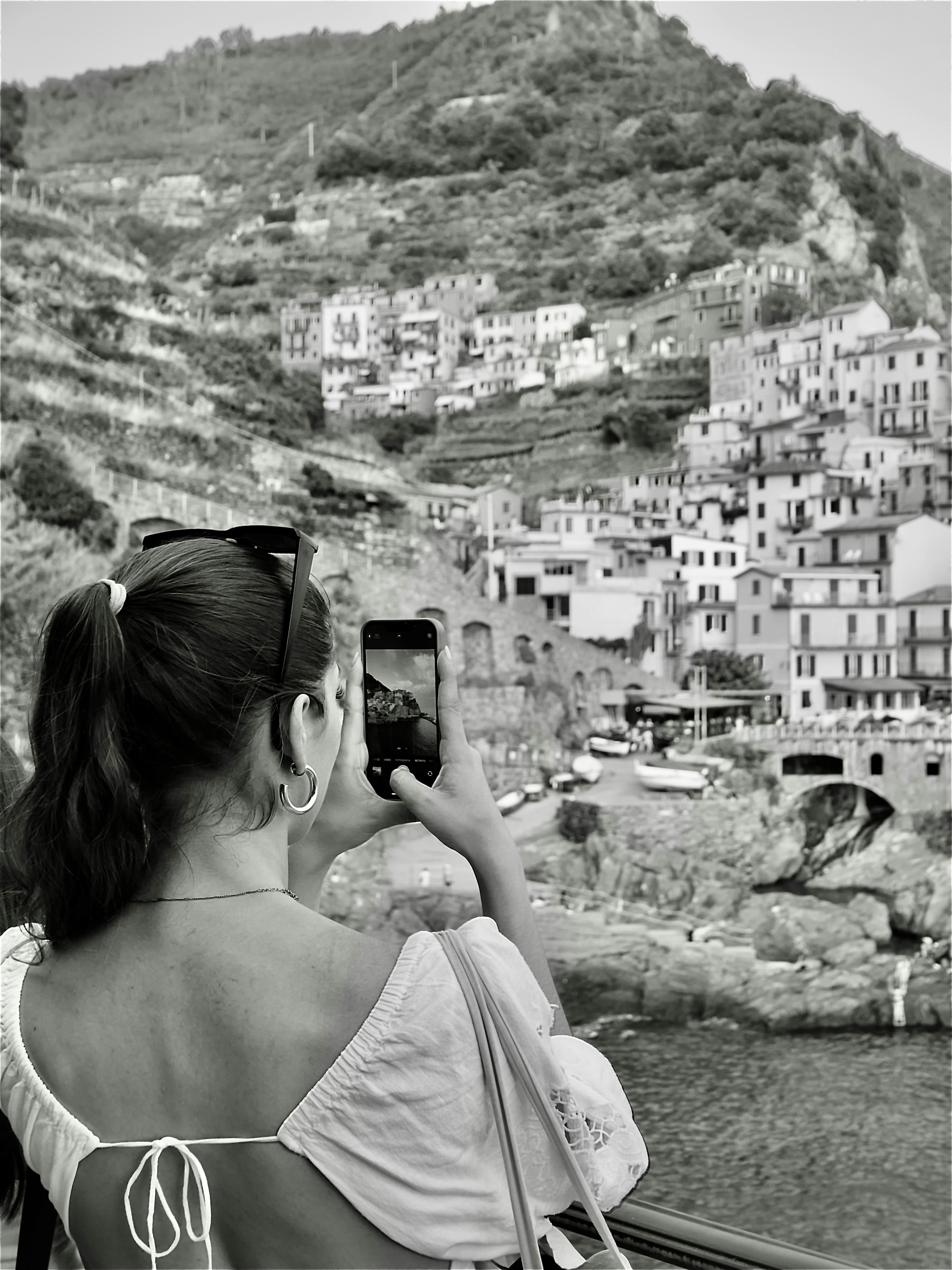 a woman taking a picture of a city with her cell phone