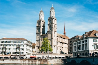 a large cathedral towering over a city next to a river