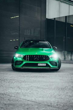 An influencer posing next to a vibrant green electric vehicle in an urban setting.