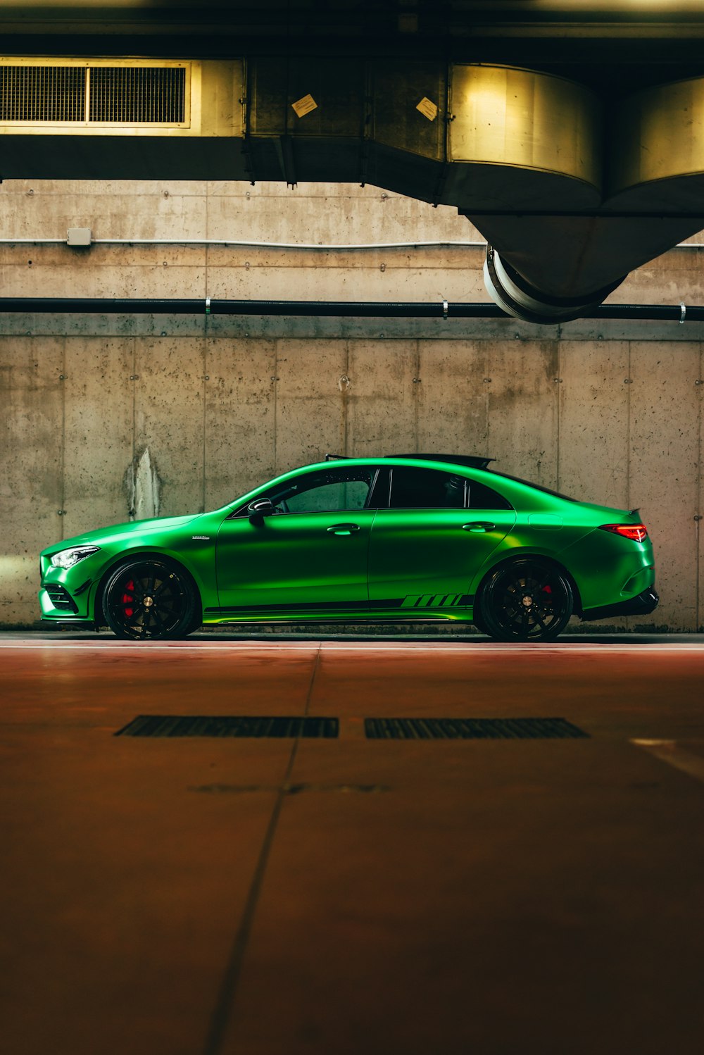 a green car parked in a parking garage