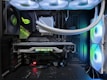 A high-end gaming or performance PC interior equipped with RGB lighting and multiple cooling fans. The graphics card prominently displayed is a GeForce RTX model, with branding visible. The setup includes neatly managed cables and a liquid cooling system.