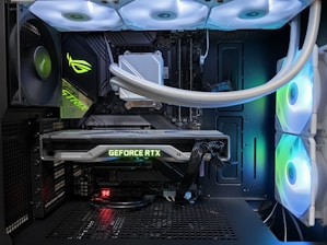 A high-end gaming or performance PC interior equipped with RGB lighting and multiple cooling fans. The graphics card prominently displayed is a GeForce RTX model, with branding visible. The setup includes neatly managed cables and a liquid cooling system.