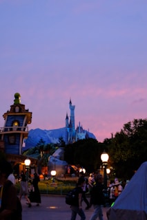 Golden hour glow over Cinderella Castle with guests strolling in Fantasyland