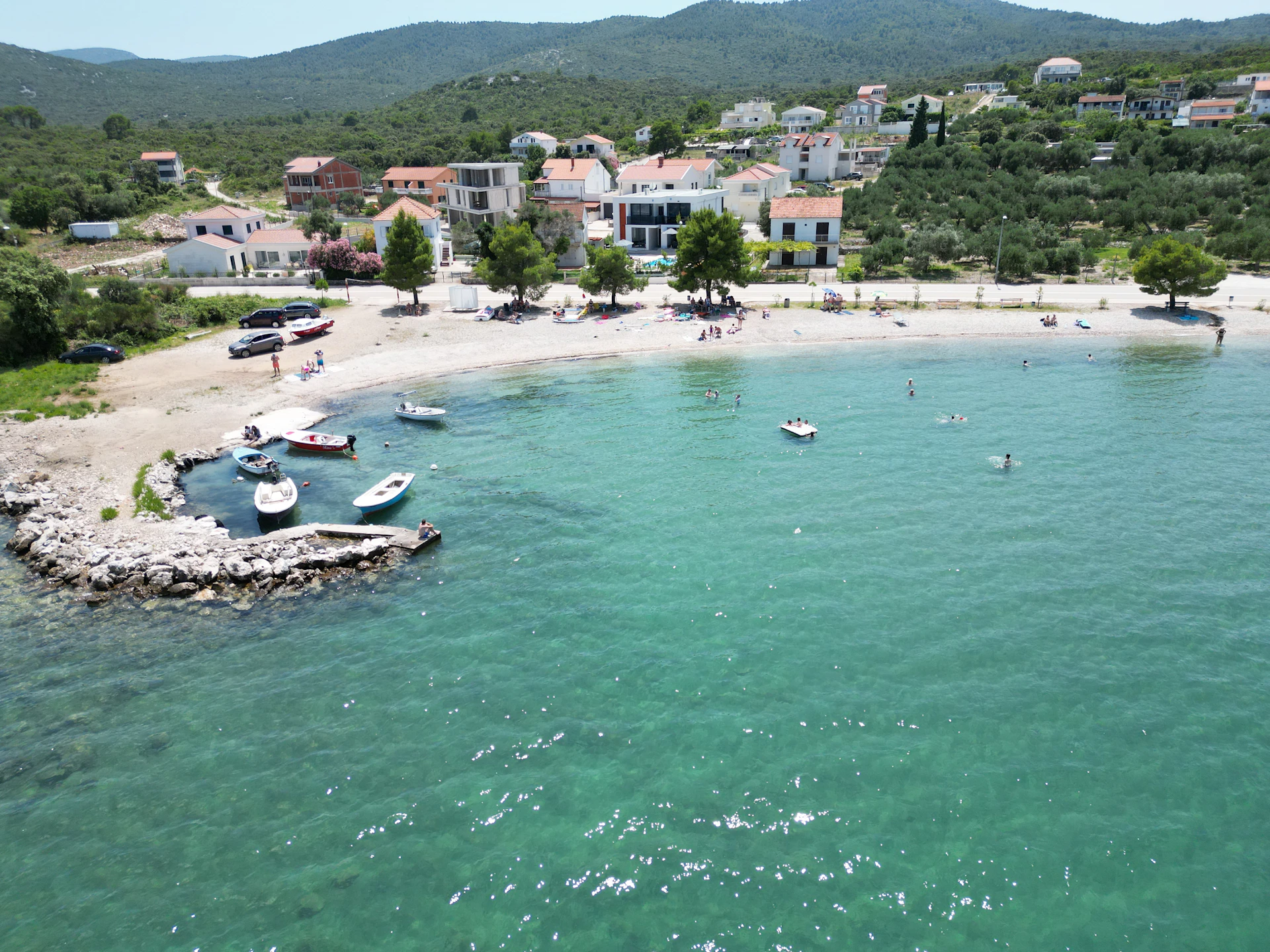 an aerial view of a beach with boats in the water