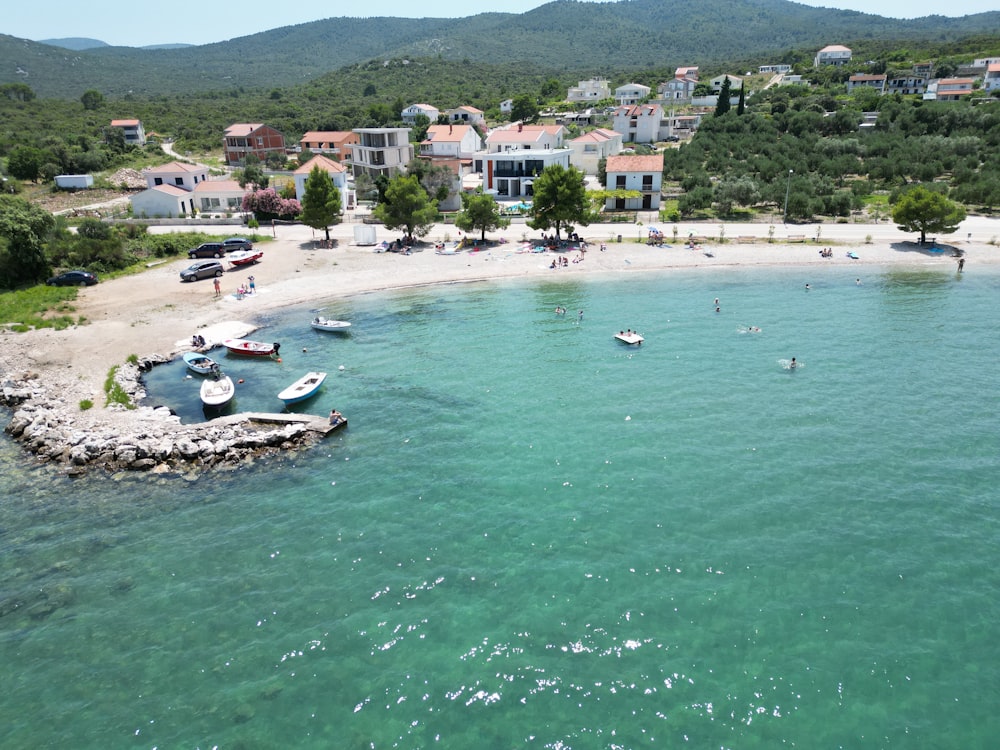 an aerial view of a beach with boats in the water