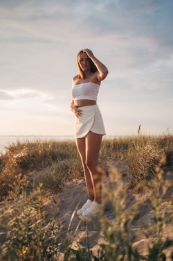 A sunny beach scene with a model wearing a light, breezy beach outfit.