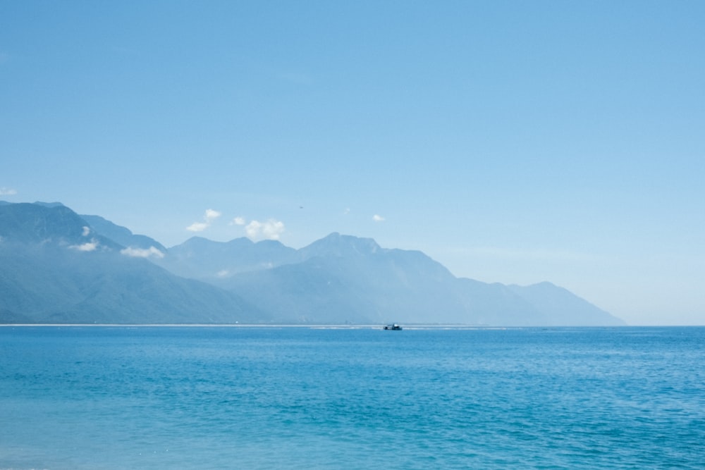 a large body of water with mountains in the background