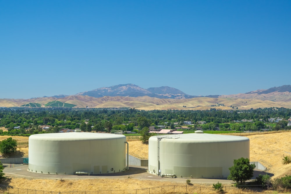 a couple of large tanks sitting on top of a dry grass field