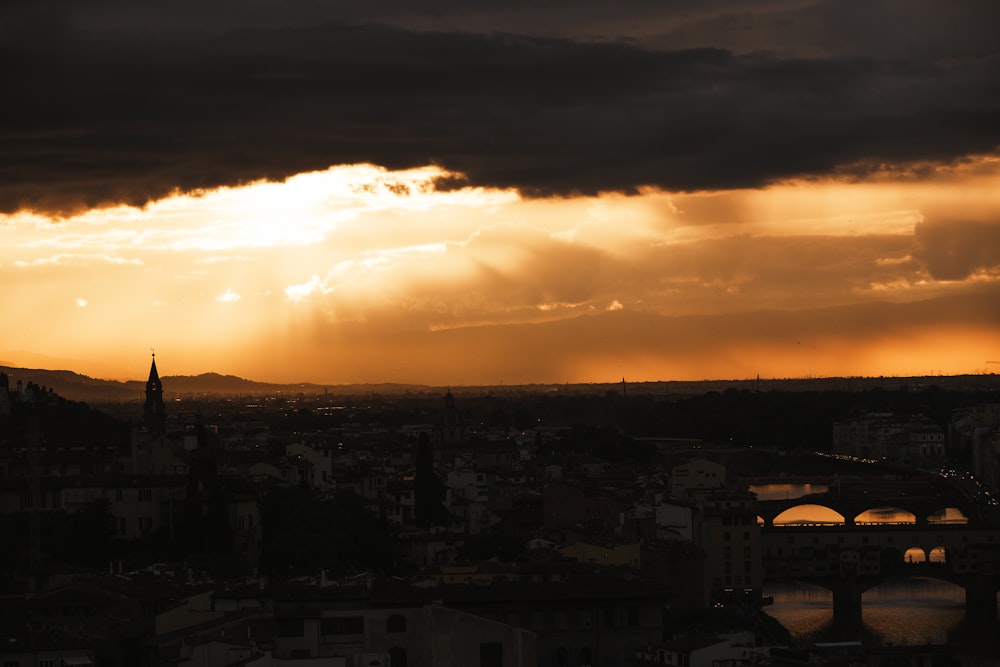 the sun is shining through the clouds over a city