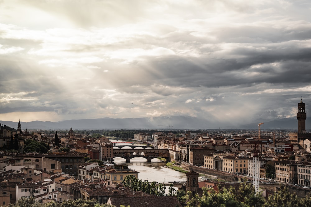 a river running through a city under a cloudy sky