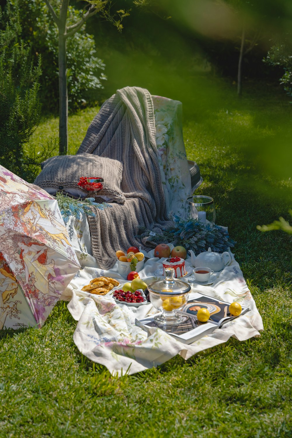 a picnic set up in the grass with an umbrella