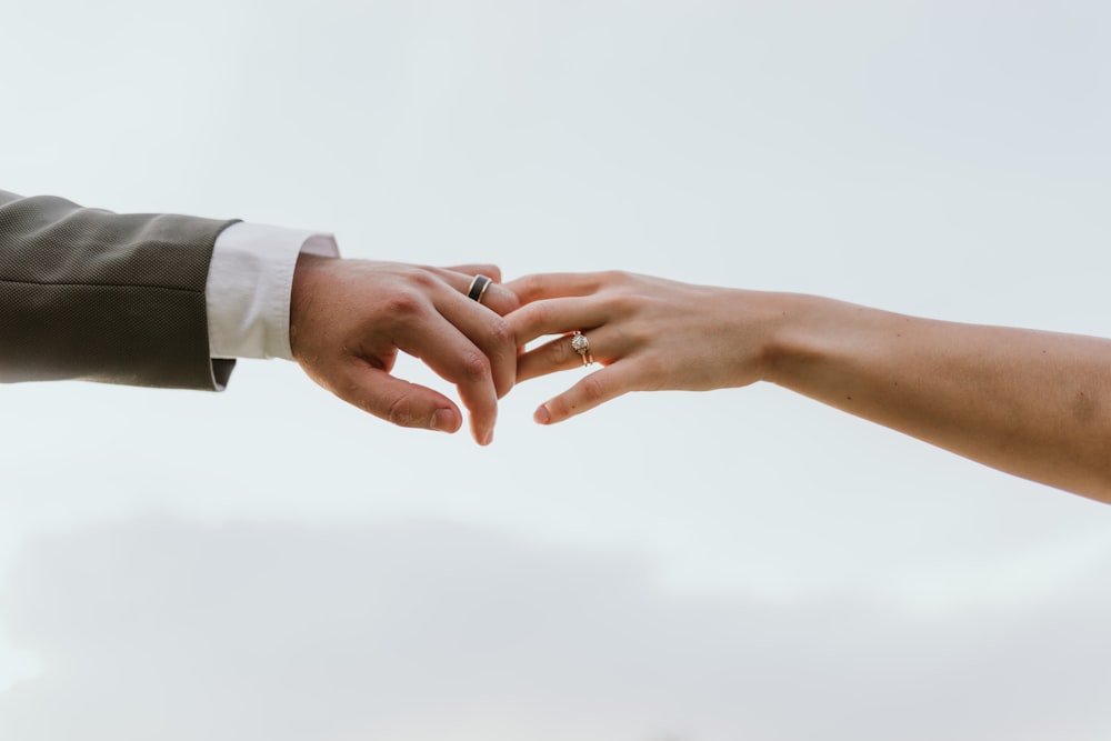 a close up of two people holding hands