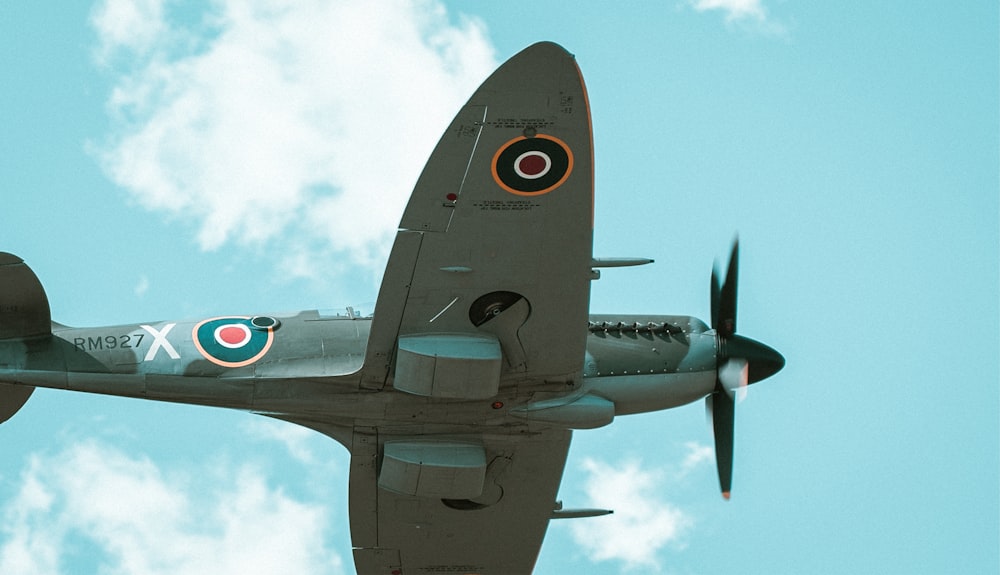 a fighter jet flying through a cloudy blue sky