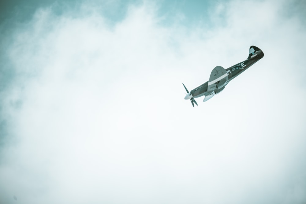 a small airplane flying through a cloudy sky