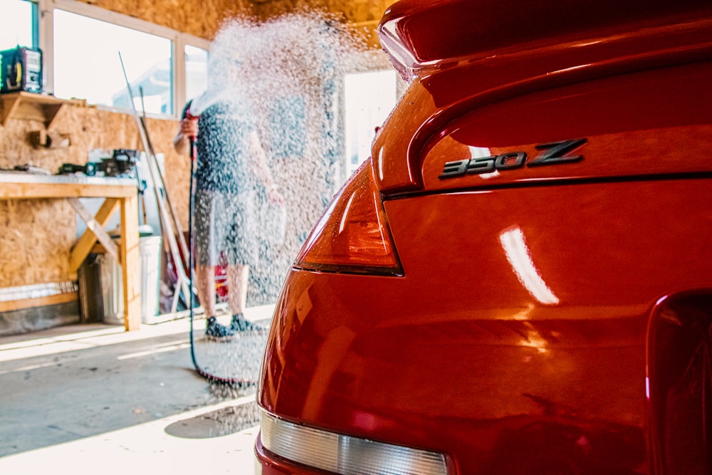 the back end of a red car in a garage