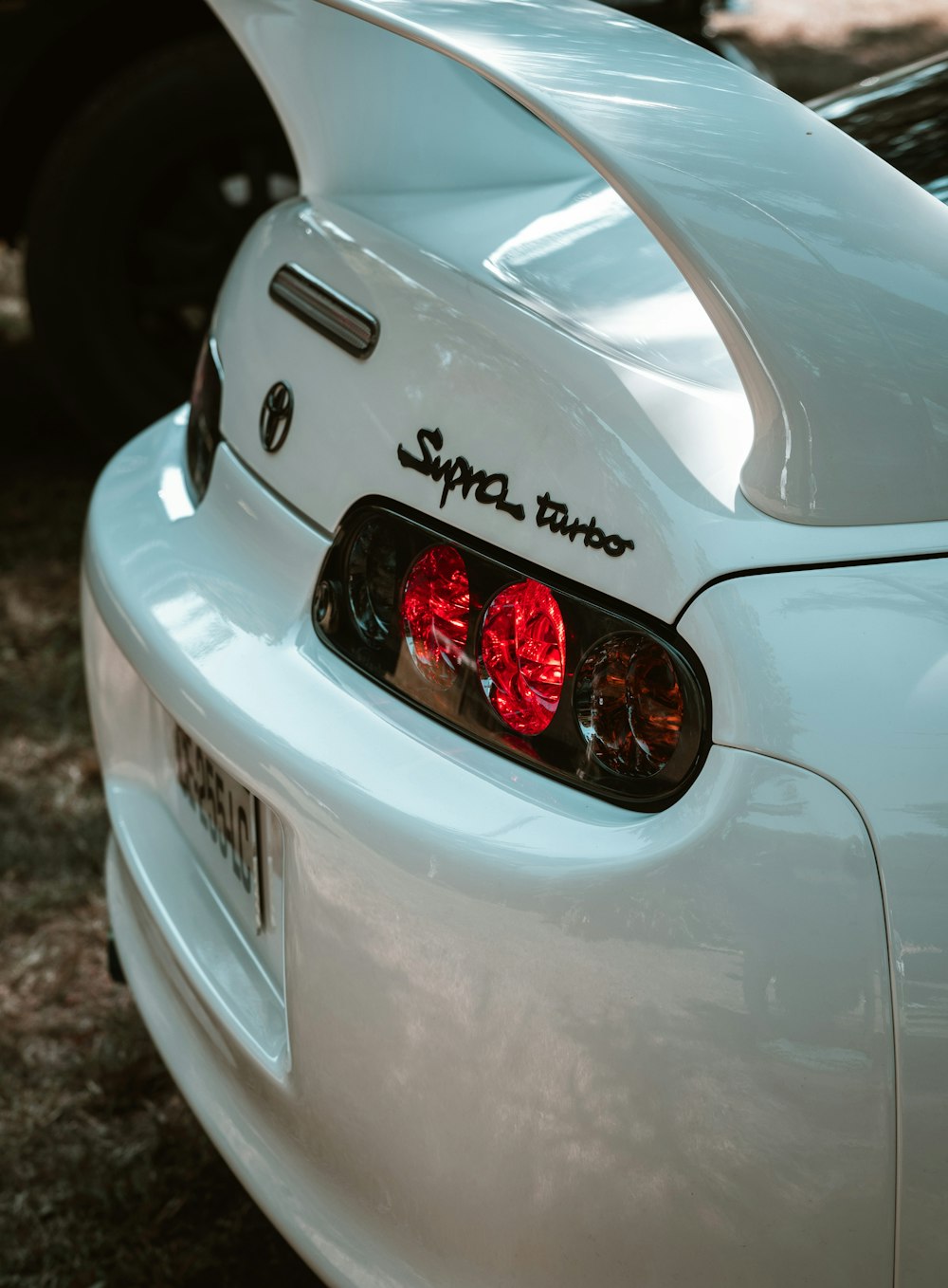 a close up of the tail lights of a white sports car