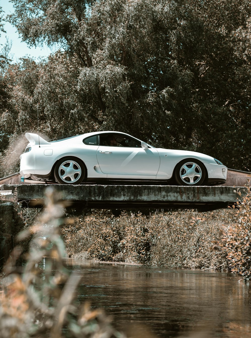a white sports car sitting on top of a bridge