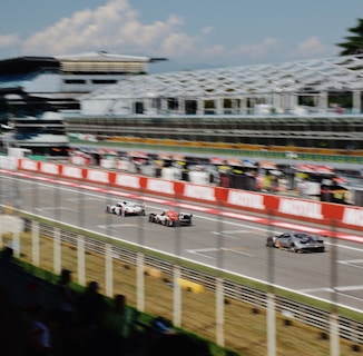 a group of cars driving down a race track