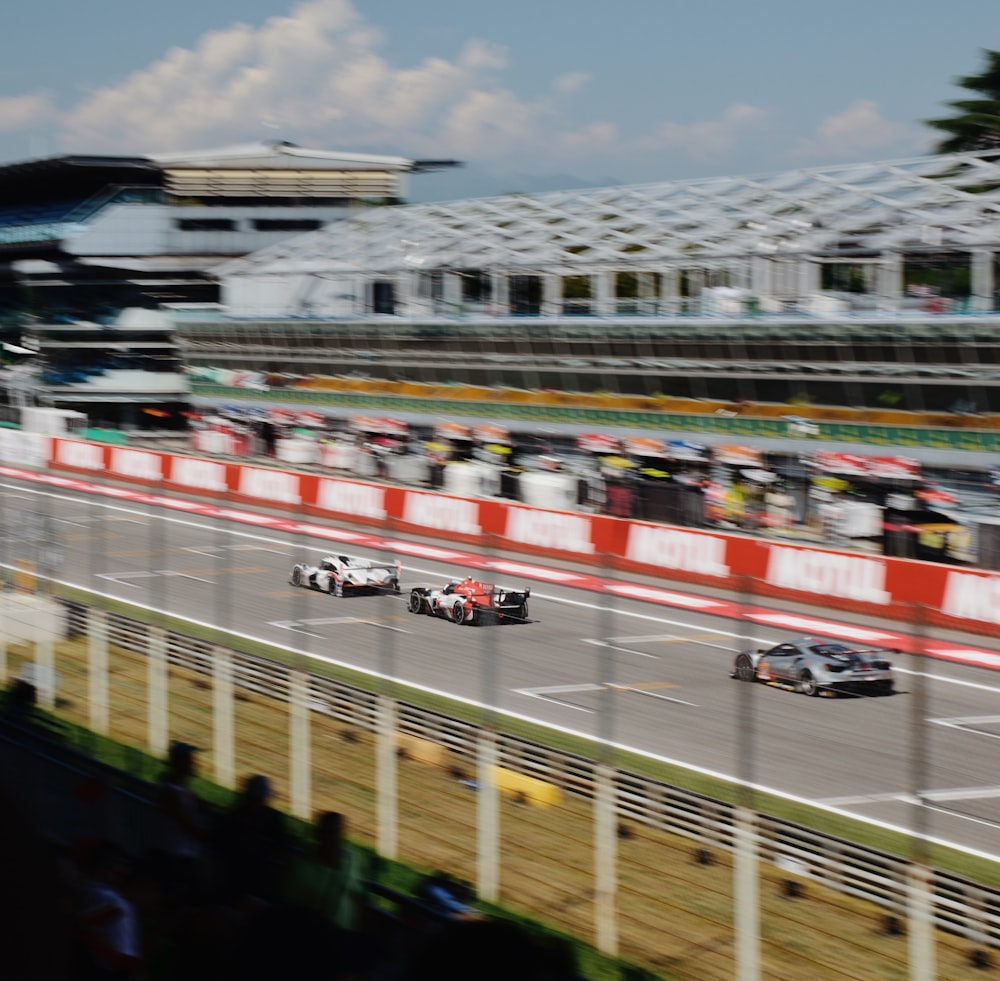 a group of cars driving down a race track