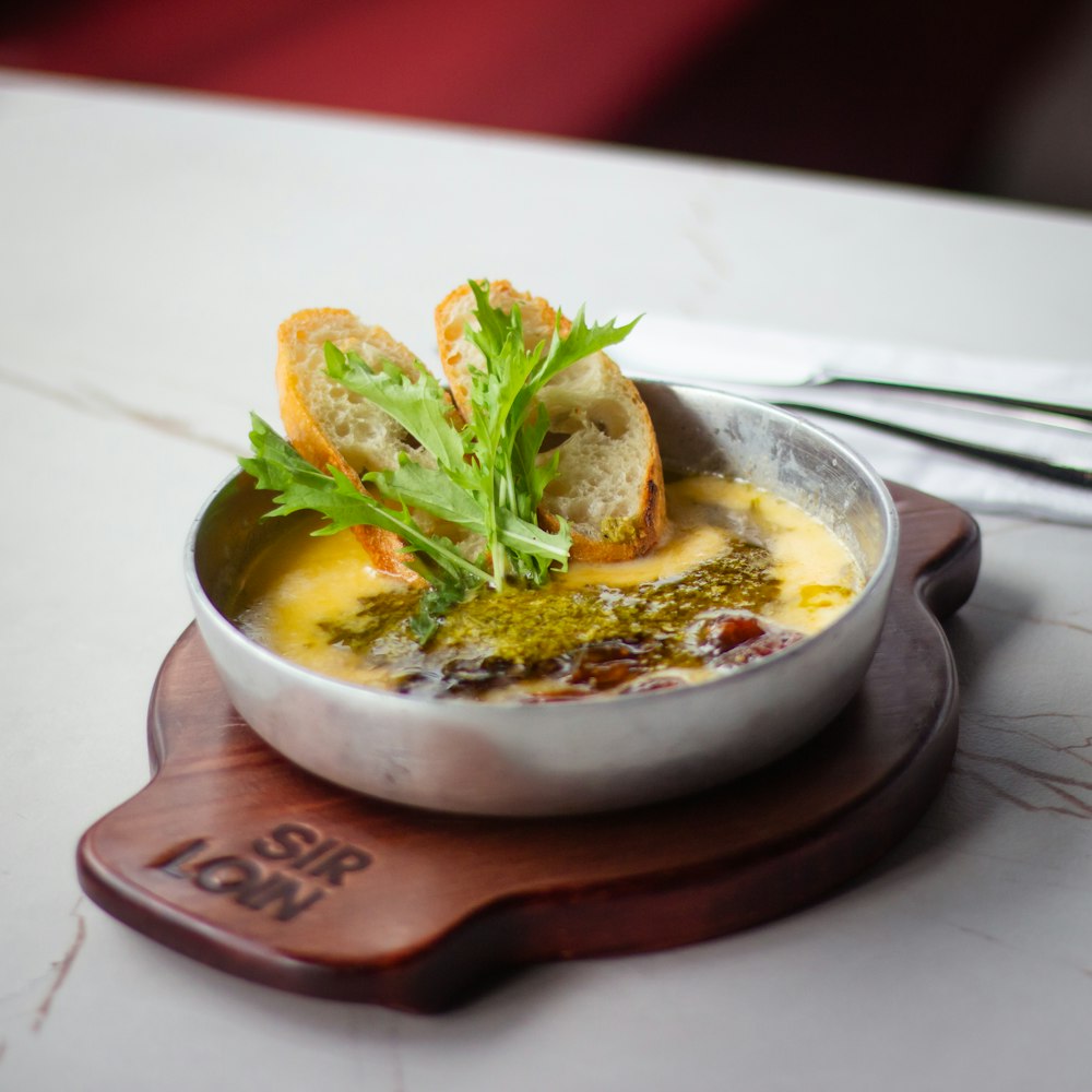 a bowl of soup with bread and parsley