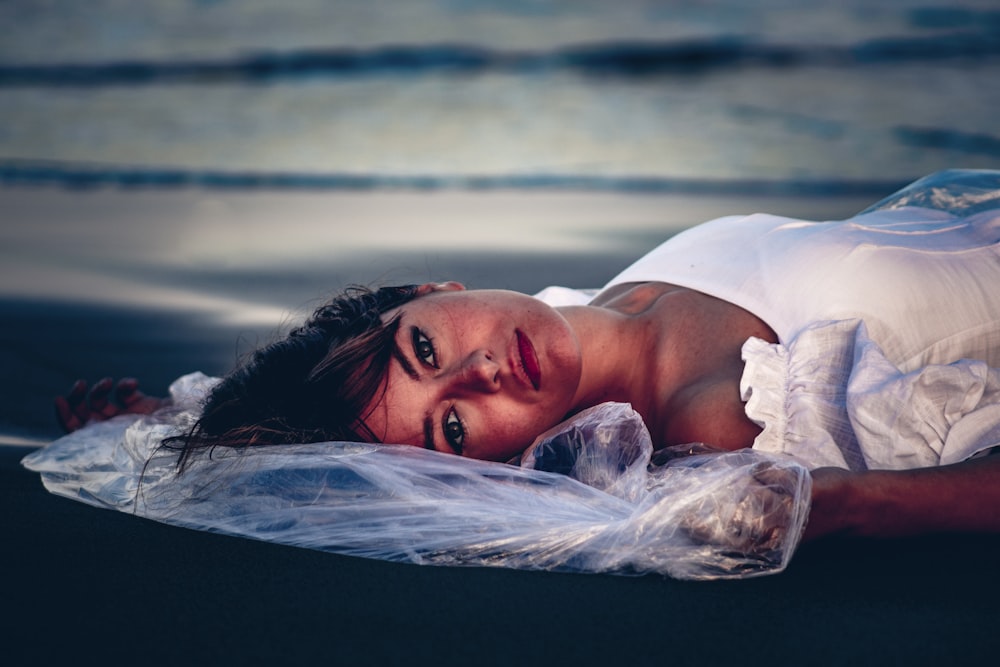 a woman in a white dress laying on the ground