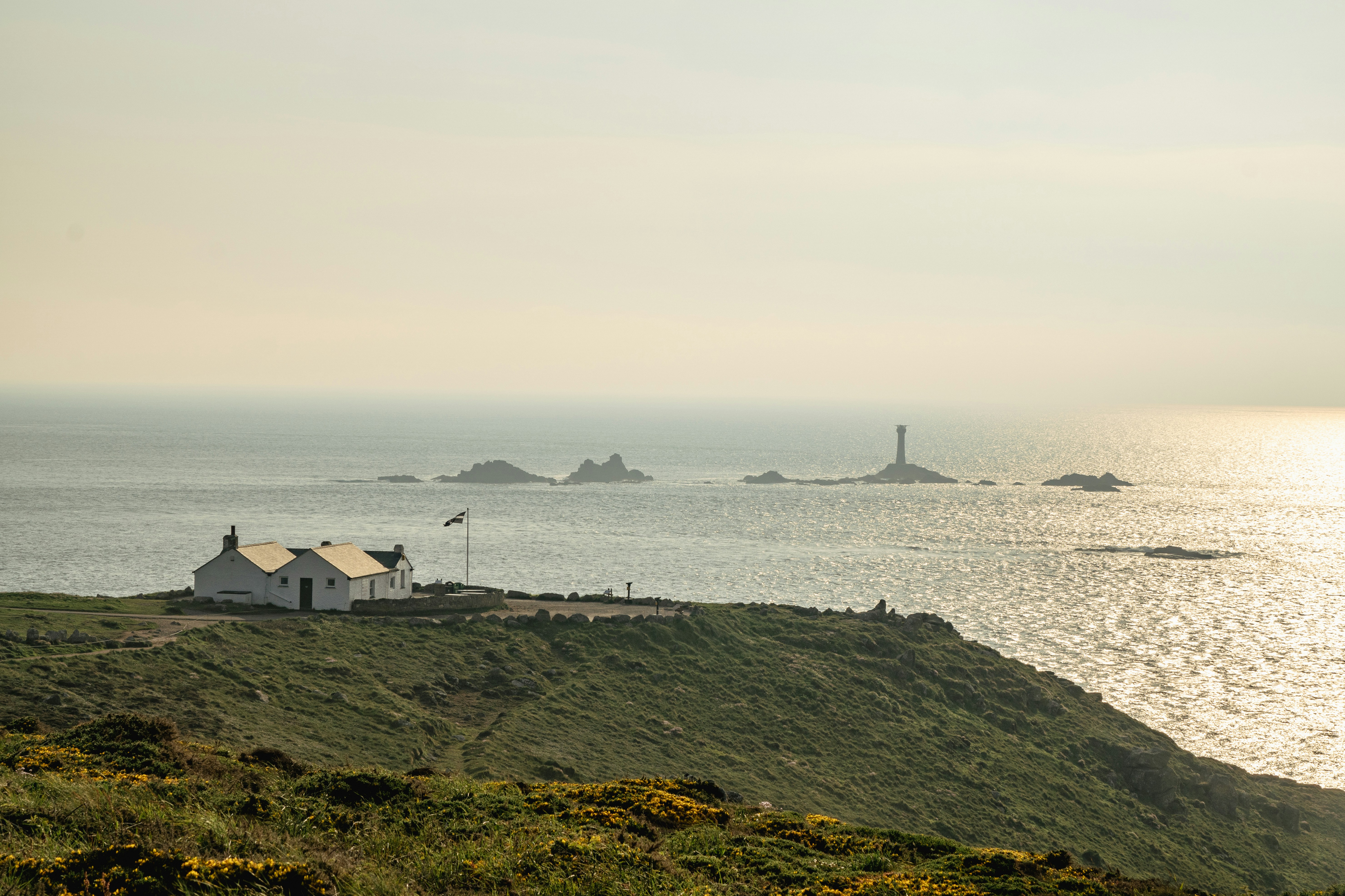 ein Haus auf einem Hügel mit Blick auf ein Gewässer