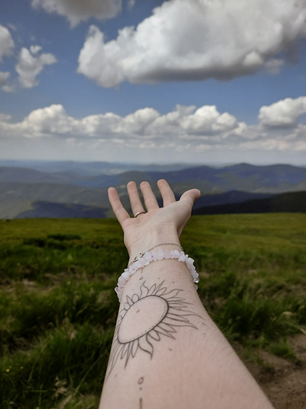 a person's arm with a sun tattoo on it