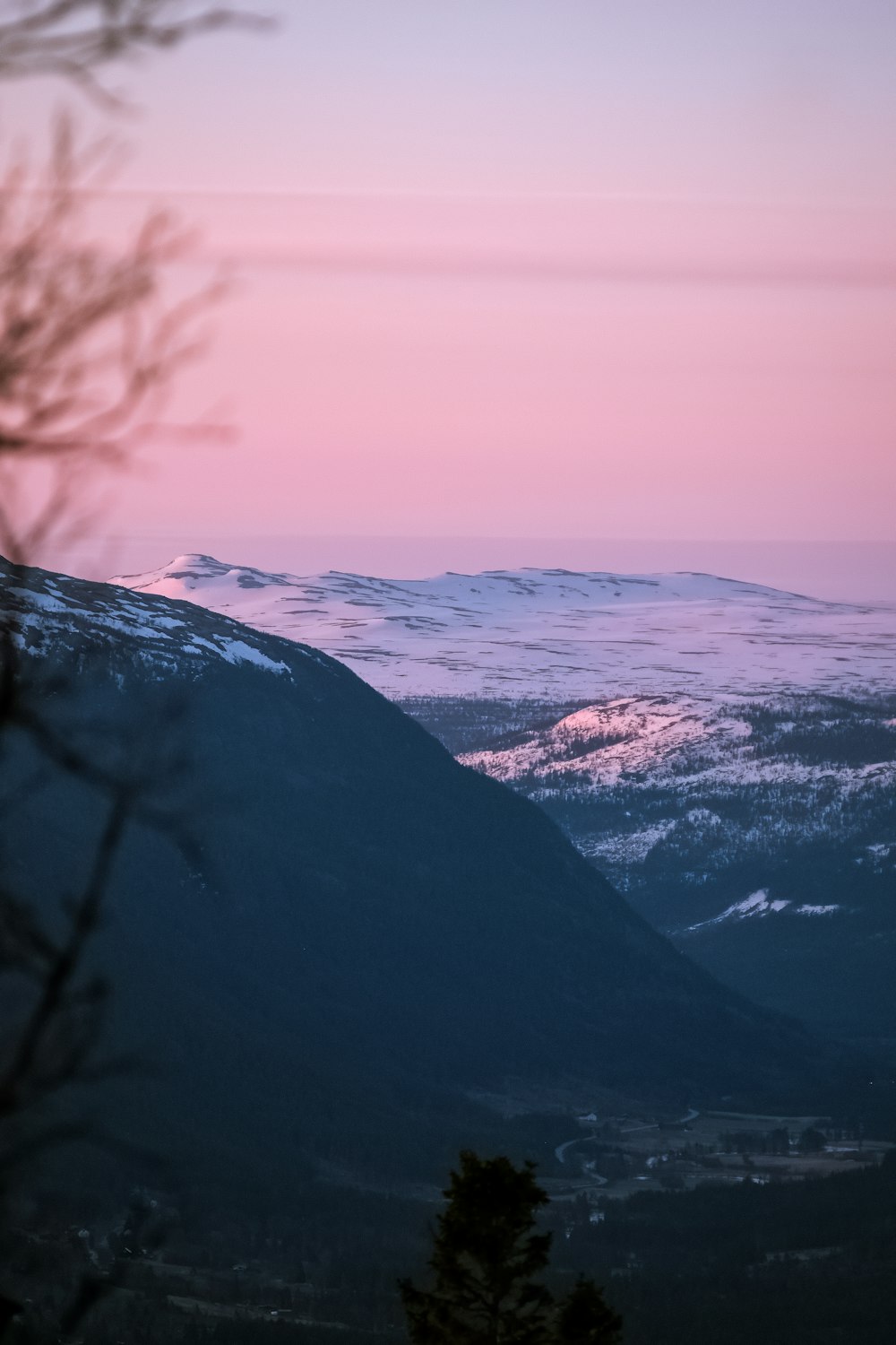 a view of a mountain with a pink sky in the background