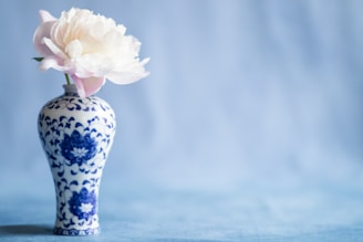 A soft taupe ceramic sculpture of a blooming peony with intricate petal details and a matte finish.