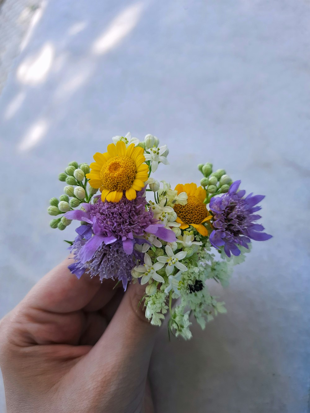 a person holding a bunch of flowers in their hand