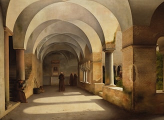 A serene walkway with arched ceilings and columns cast subtle shadows. Monks in robes are scattered around; one sits reading, while two others stand in conversation further down the corridor. Sunlight filters through small windows, illuminating the stone and brick textures. The atmosphere feels calm and introspective.