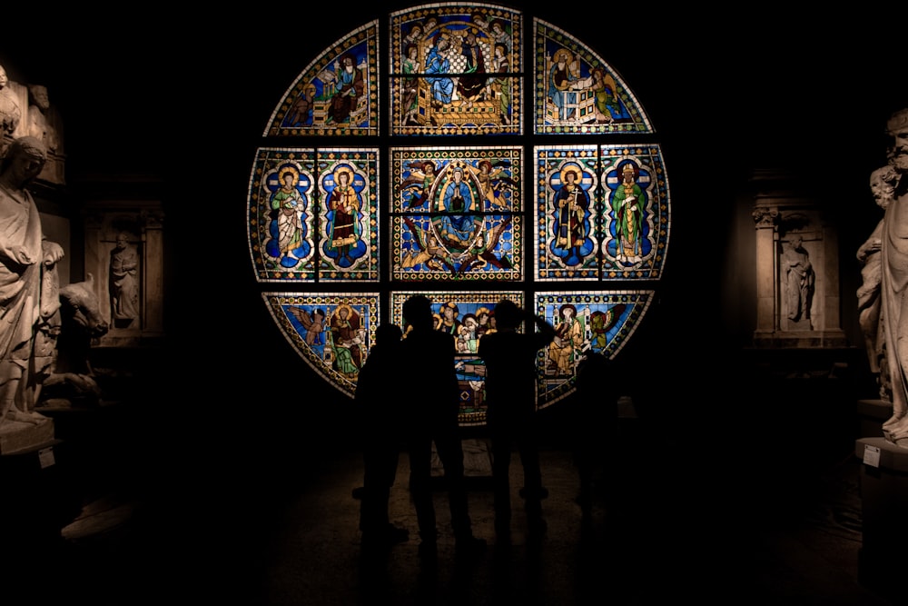 two people standing in front of a stained glass window