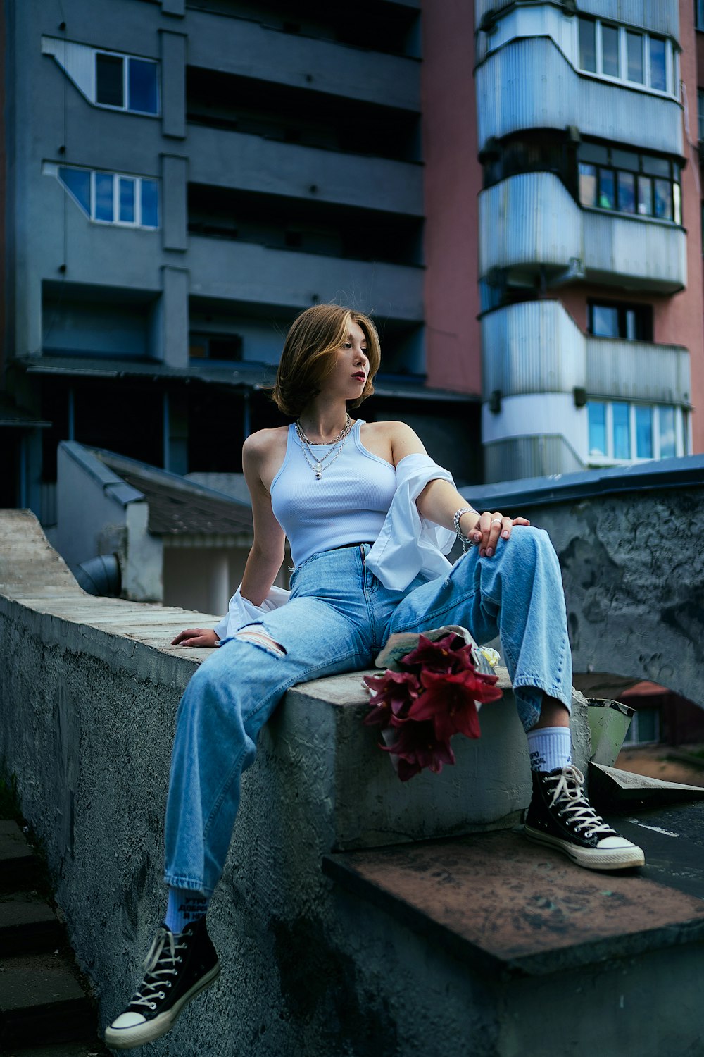 a woman sitting on a ledge in front of a building