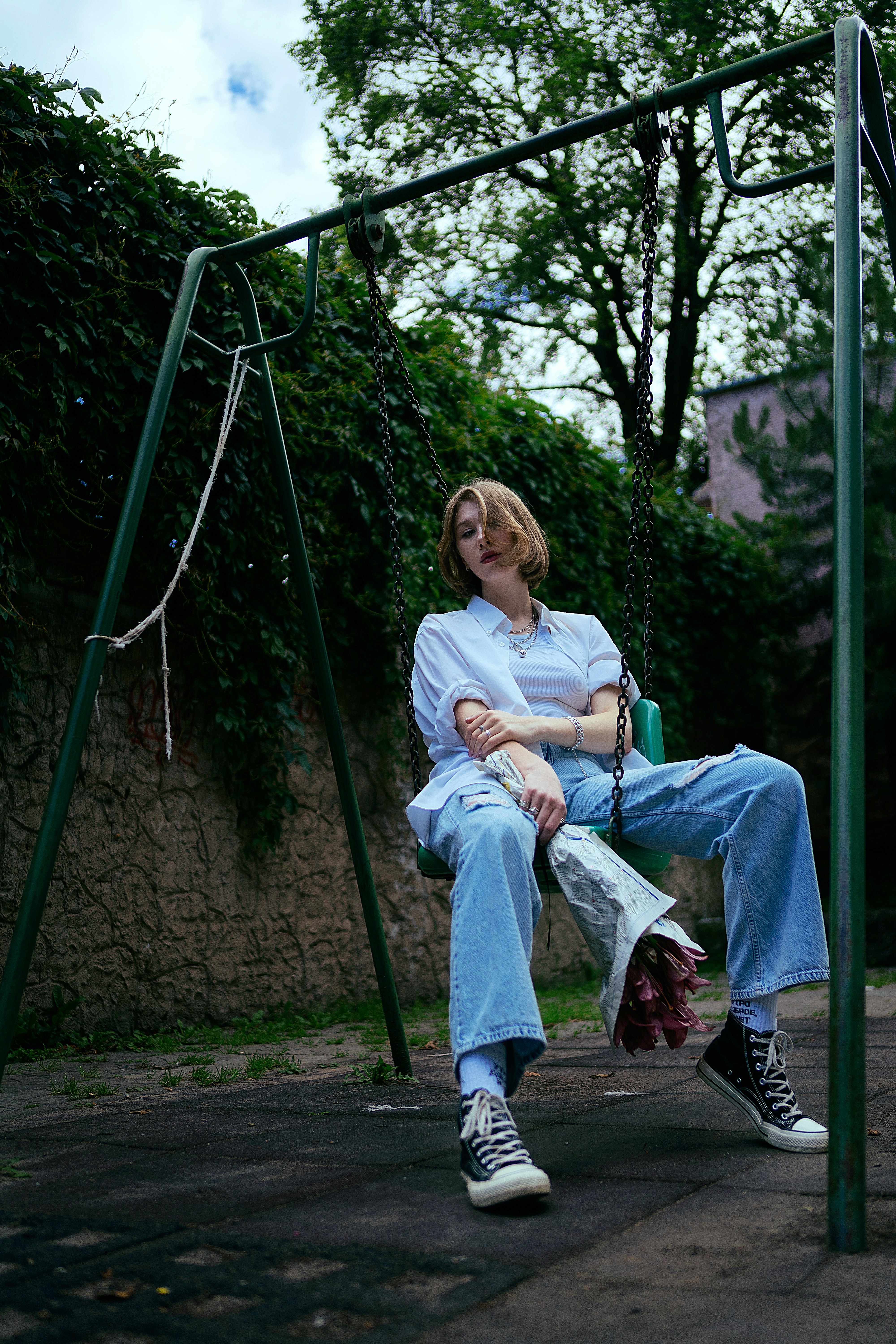 a woman sitting on a swing in a park
