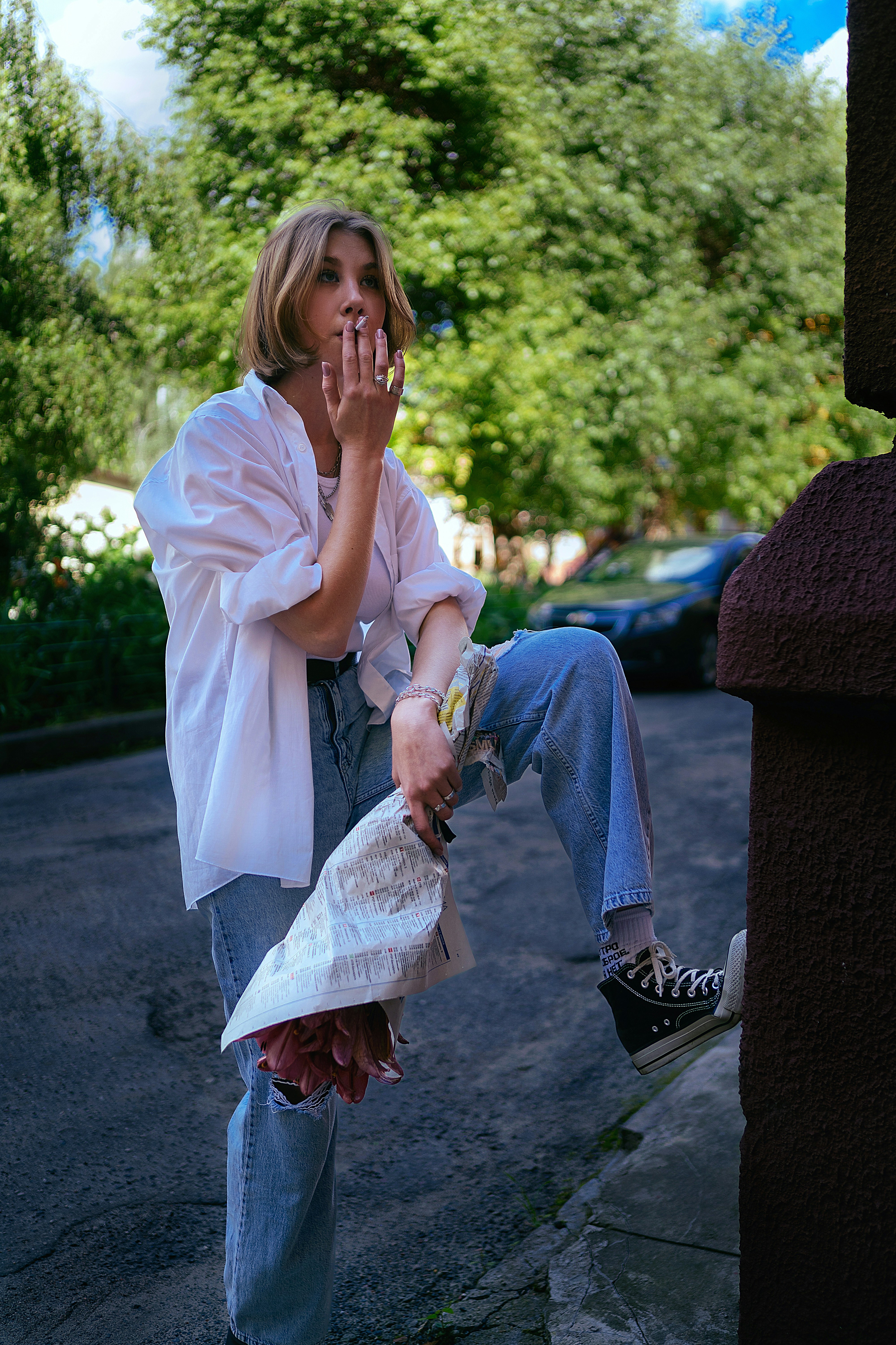 a woman sitting on a curb talking on a cell phone