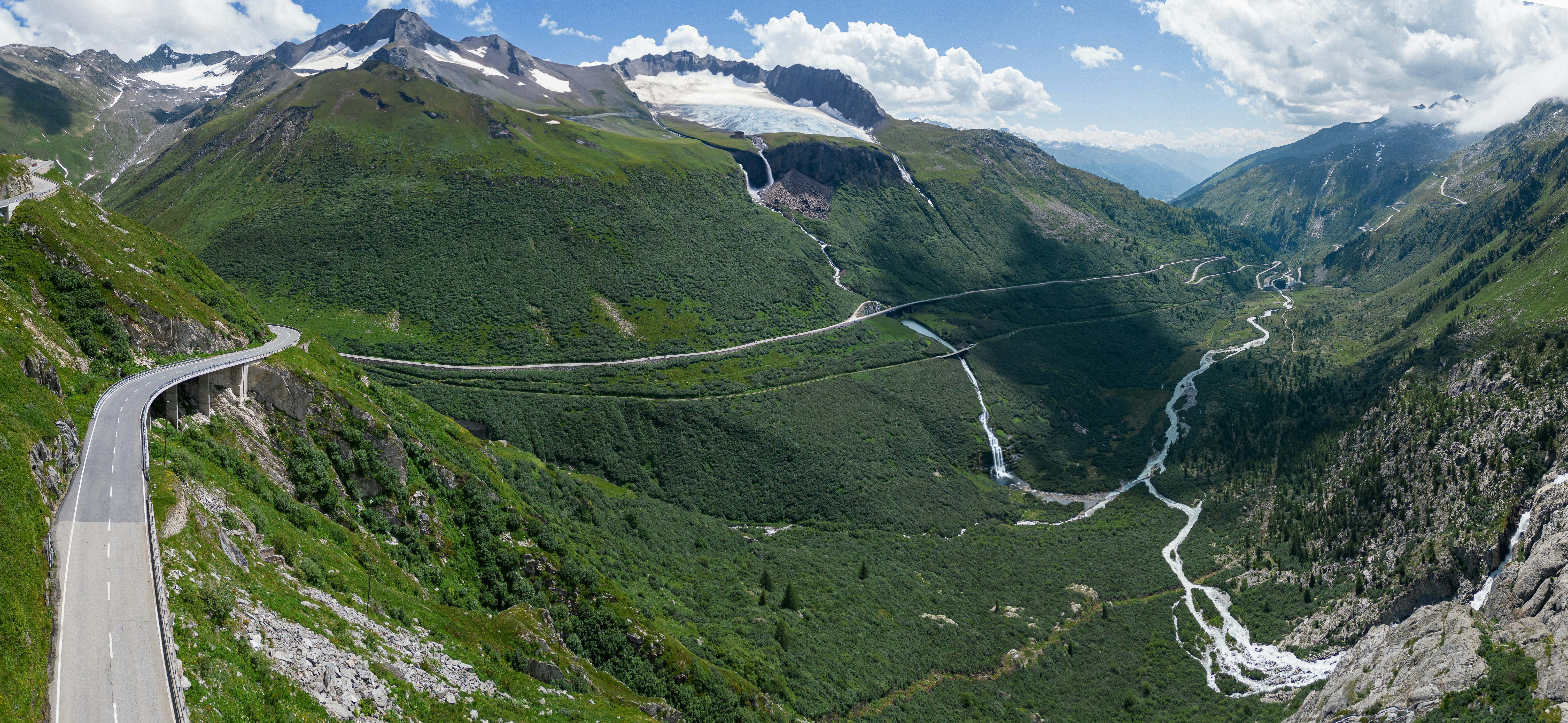 a scenic view of a winding road in the mountains