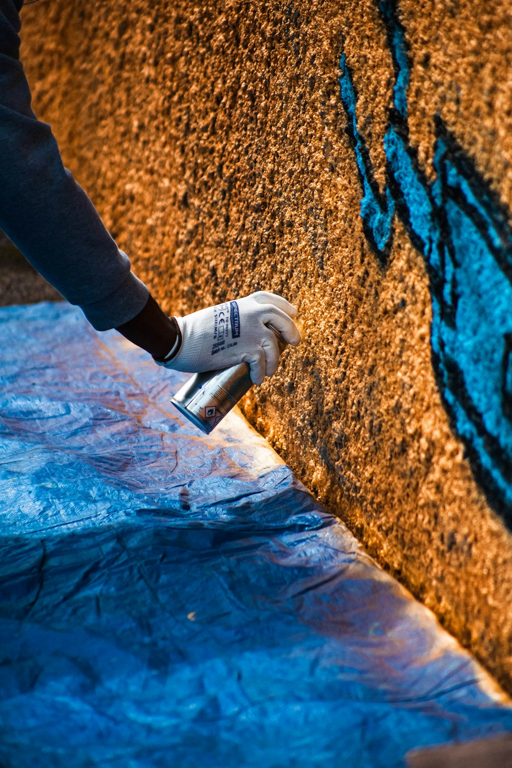 a person is painting a wall with blue paint