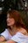 a woman in a white dress sitting on a bench