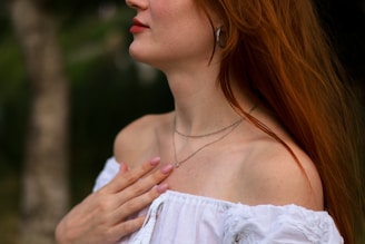 a woman with red hair wearing a white shirt