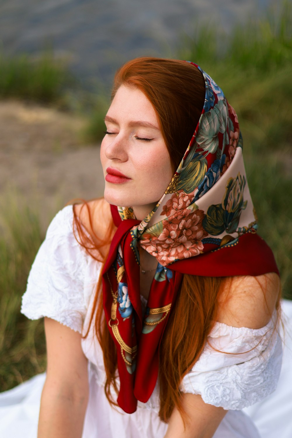 a woman with red hair wearing a scarf