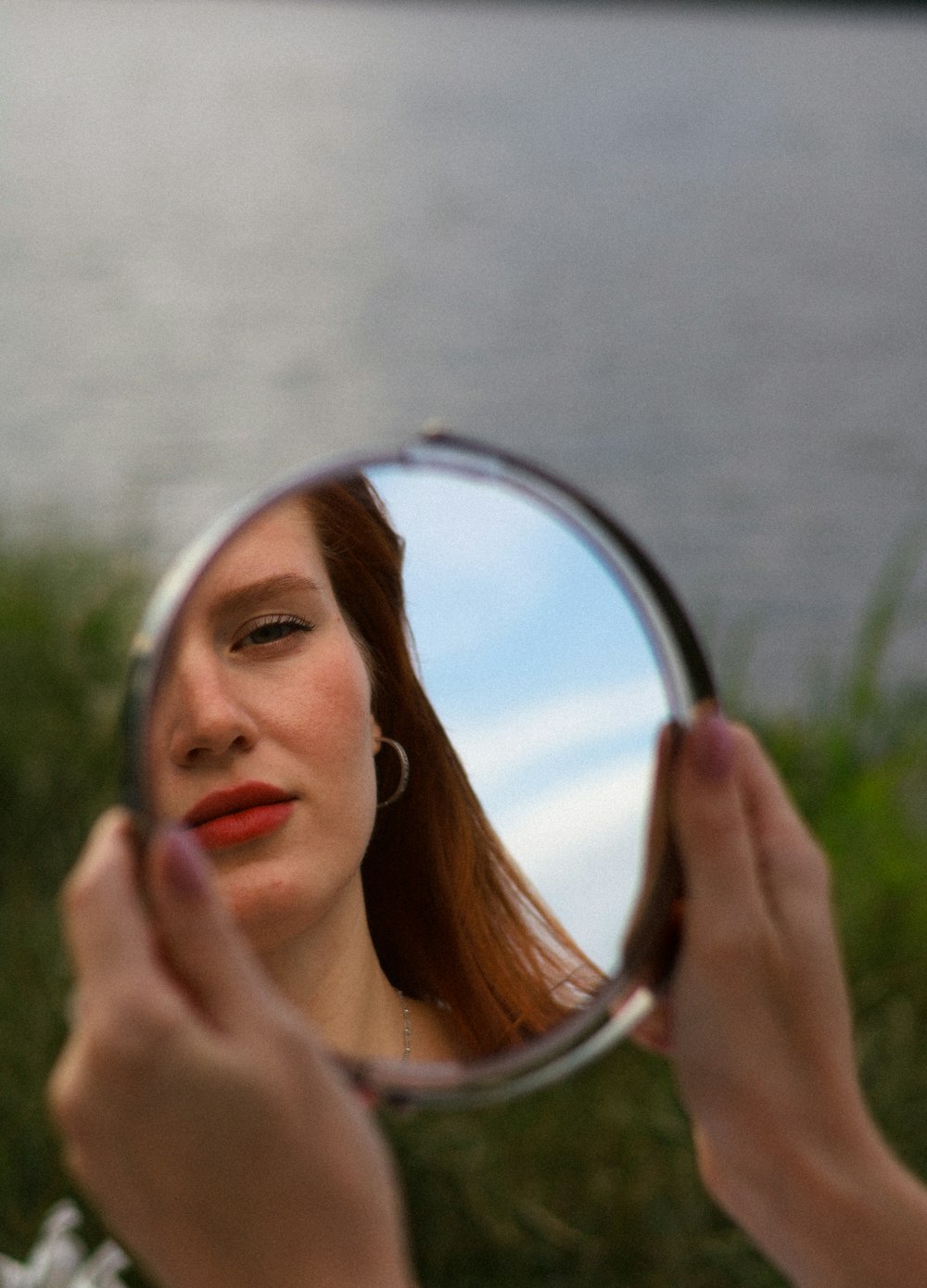 a woman looking at her face in a mirror