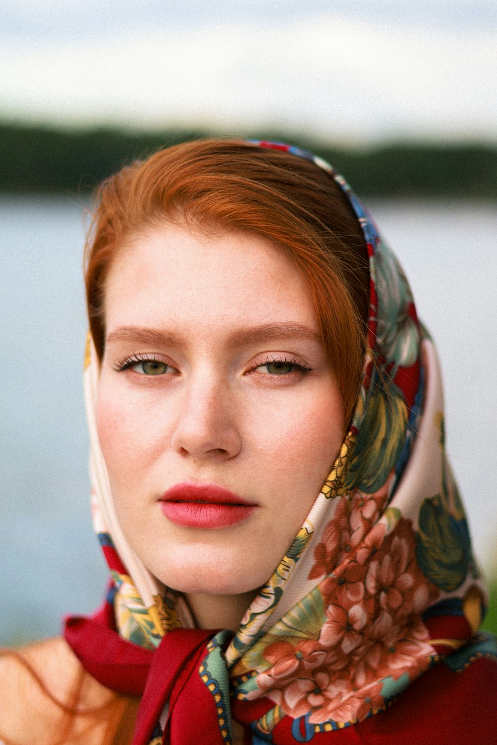a woman with red hair wearing a scarf