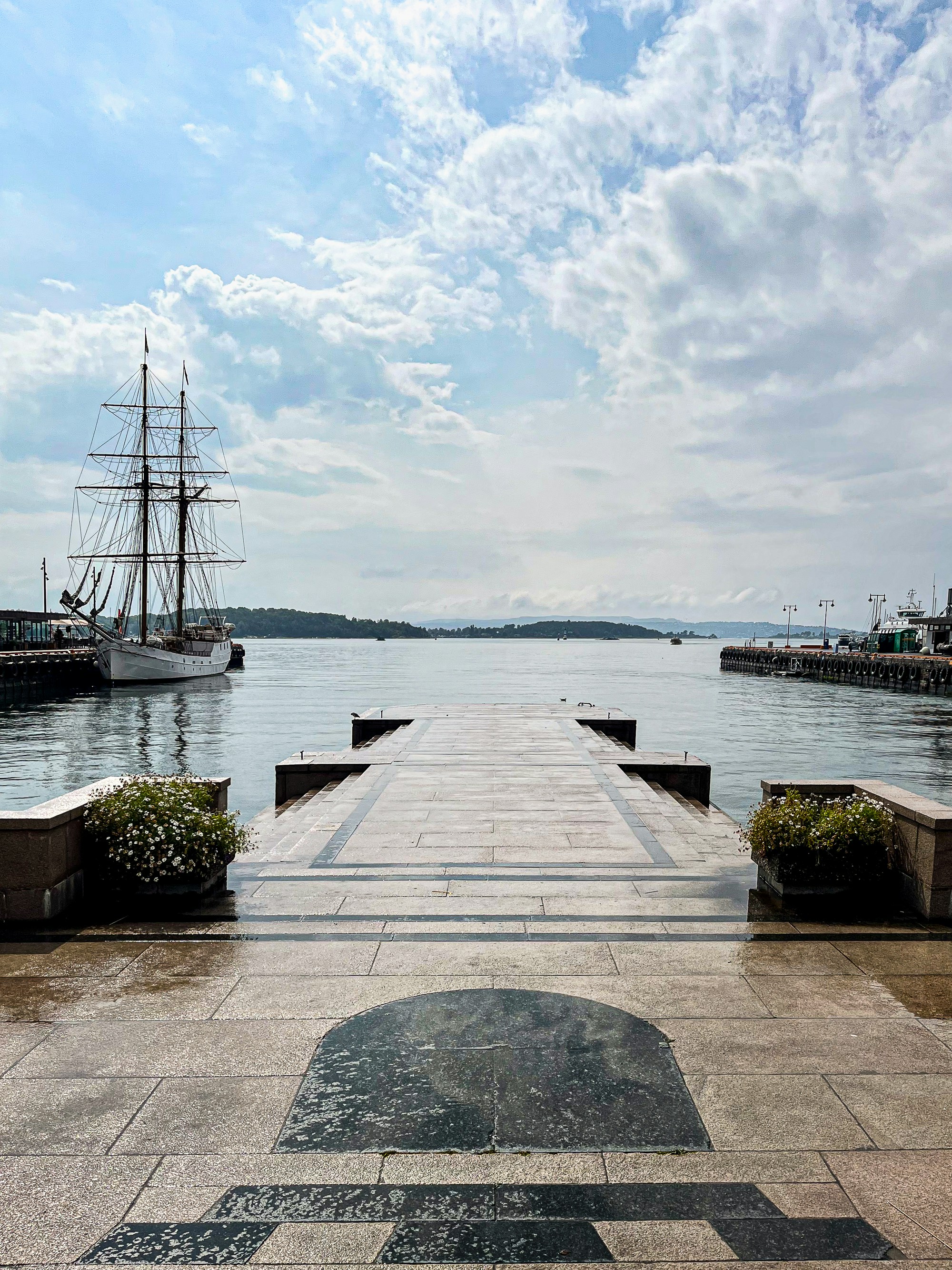 a long pier with a ship in the background