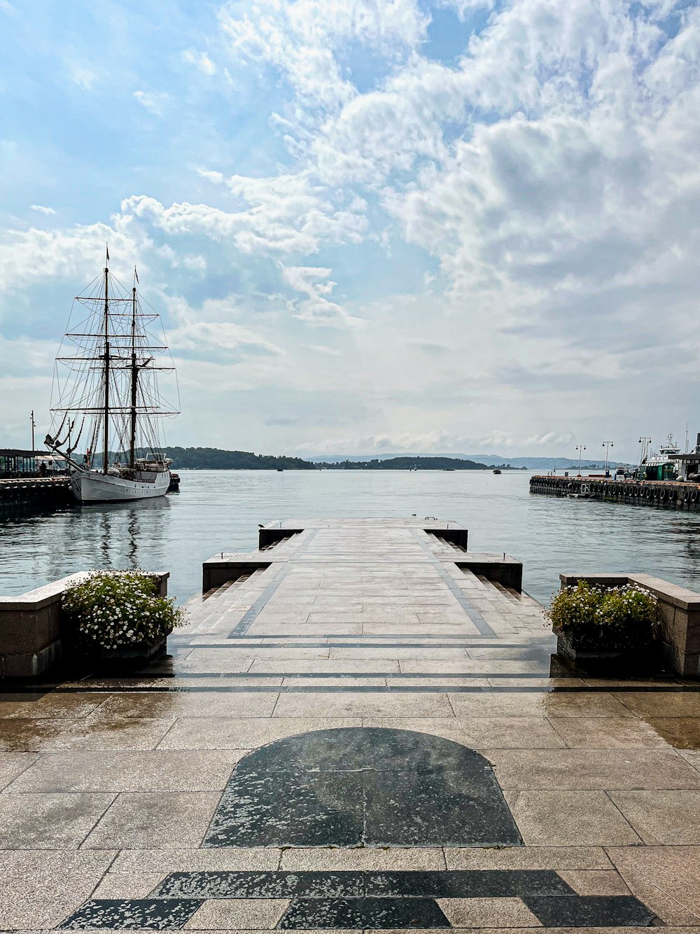 a long pier with a ship in the background