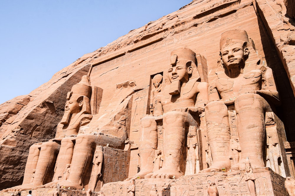 estátuas de faraós e rainhas em frente a um grande edifício